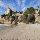Imatge de la platja de Tamarit amb el castell de fons.
