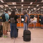 Persones esperant per utilitzar una màquina de venda de bitllets a l'estació de Sants