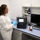 Una de les tècniques del laboratori del CAT mostra el nou aparell que permet analitzar l'aigua amb rapidesa.