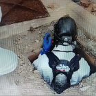 Agents de mossos entrant a la fossa sèptica on han trobat un cos.