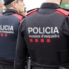 Esquena de dos agents dels Mossos d'Esquadra patrullant