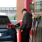 Un joven llenando el depósito en una gasolinera.