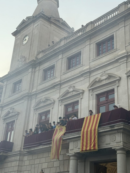 Joves amb l’estelada al balcó de l’Ajuntament abans que el membre de seguretat els fes retirar-la.
